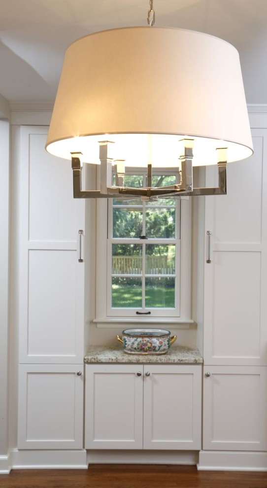 Inspiration for a mid-sized transitional l-shaped dark wood floor eat-in kitchen remodel in Cedar Rapids with a farmhouse sink, shaker cabinets, white cabinets, granite countertops, white backsplash, subway tile backsplash, stainless steel appliances and an island