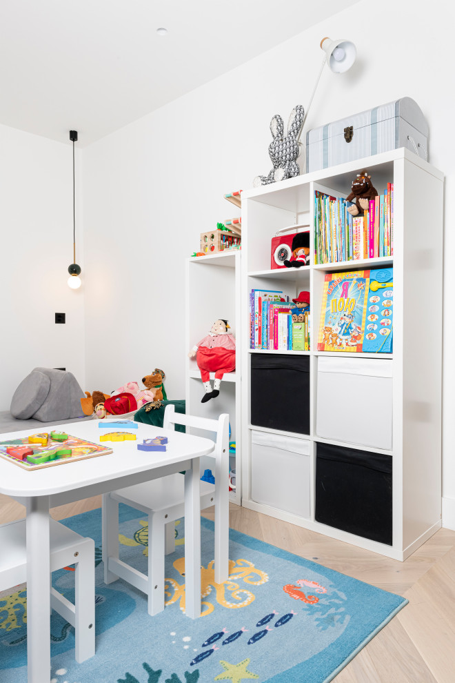 Photo of a medium sized contemporary gender neutral kids' bedroom in London with white walls, light hardwood flooring and feature lighting.