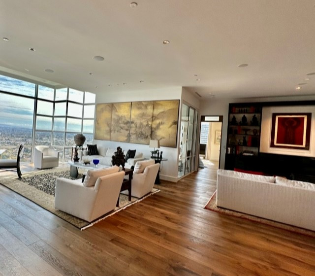 Photo of an expansive asian living room in Los Angeles with white walls, medium hardwood floors, a built-in media wall and brown floor.