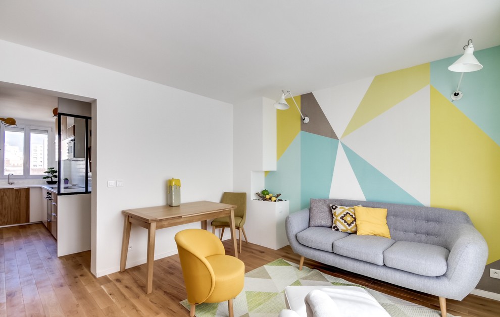 This is an example of a mid-sized scandinavian enclosed living room in Paris with multi-coloured walls, medium hardwood floors, no fireplace and no tv.