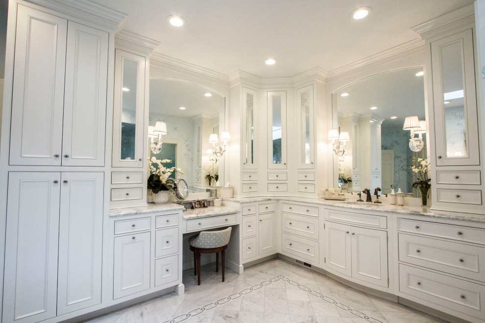 Large traditional master bathroom in St Louis with furniture-like cabinets, white cabinets, a freestanding tub, an alcove shower, a one-piece toilet, white tile, marble, blue walls, marble floors, an undermount sink, marble benchtops, white floor, a hinged shower door, white benchtops, an enclosed toilet, a double vanity, a built-in vanity and wallpaper.