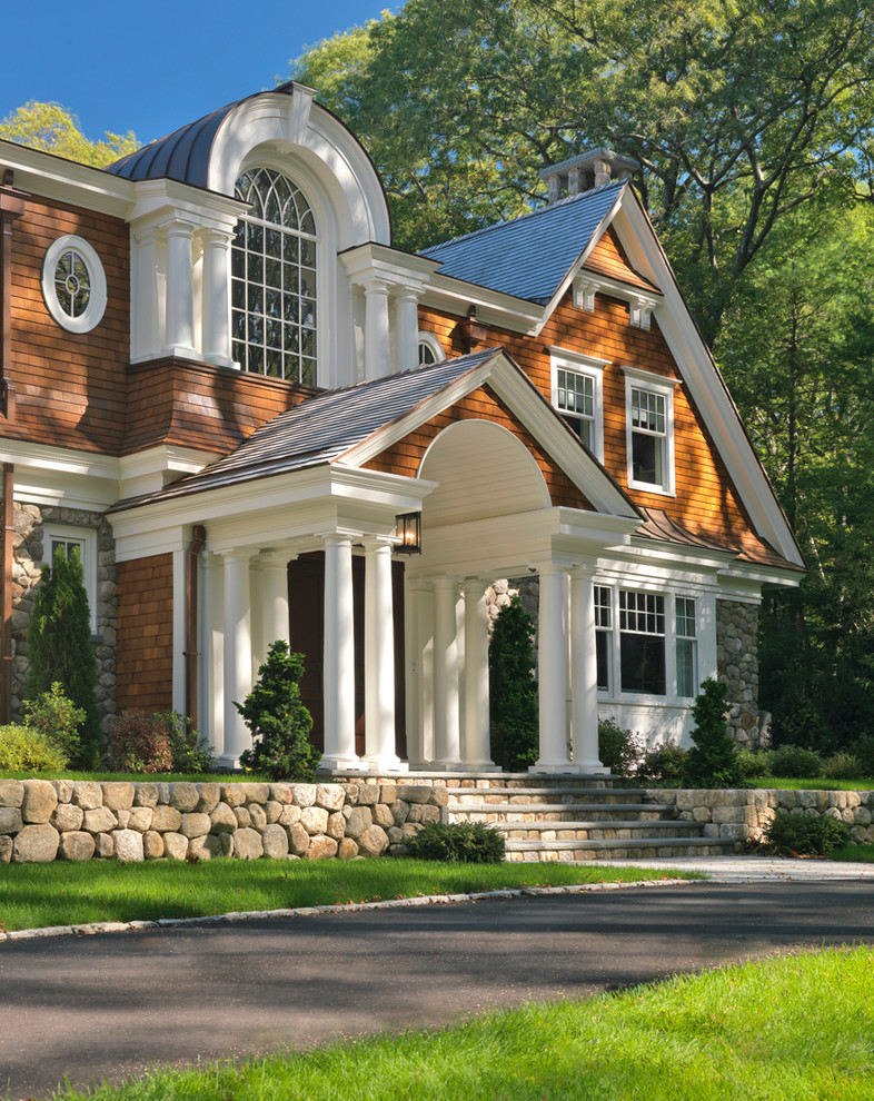 Photo of a large traditional two-storey house exterior in Boston with stone veneer, a gable roof and a shingle roof.