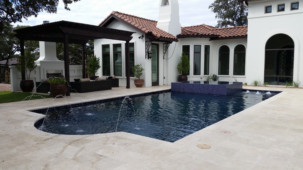 Inspiration for an expansive mediterranean backyard rectangular lap pool in Austin with a hot tub and stamped concrete.
