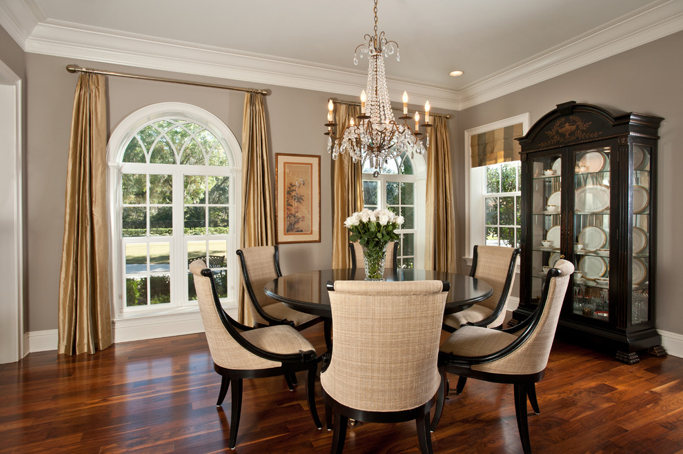Inspiration for a traditional dining room in Tampa with grey walls and dark hardwood floors.