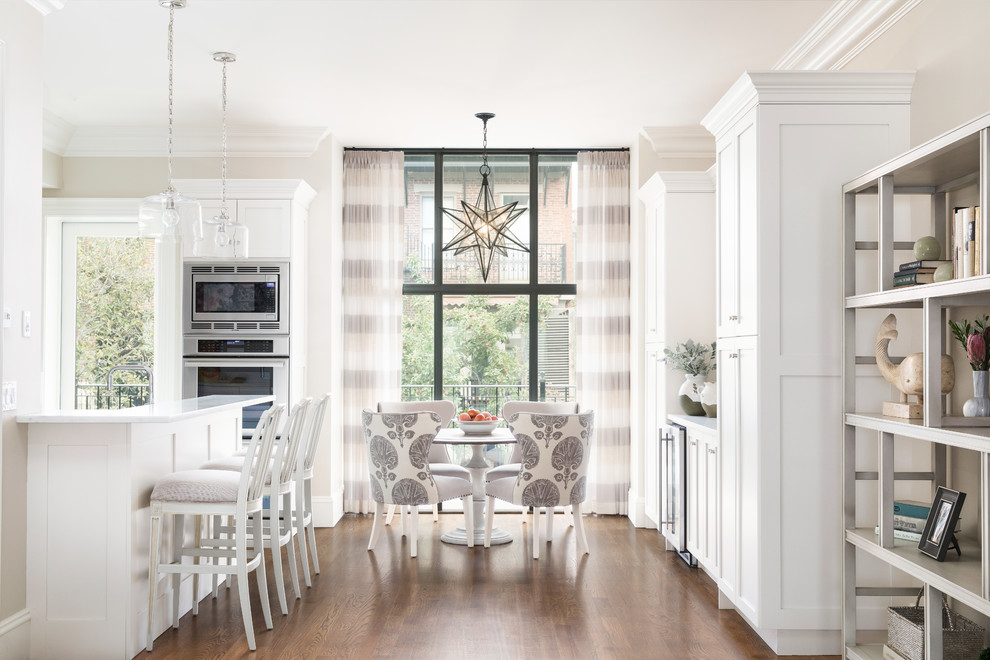 Design ideas for a traditional eat-in kitchen in Boston with shaker cabinets, white cabinets, stainless steel appliances, dark hardwood floors and brown floor.