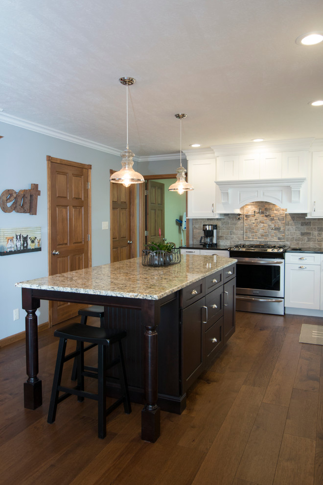 Eat-in kitchen - large transitional l-shaped medium tone wood floor eat-in kitchen idea with an undermount sink, shaker cabinets, white cabinets, granite countertops, gray backsplash, stone tile backsplash, stainless steel appliances and an island