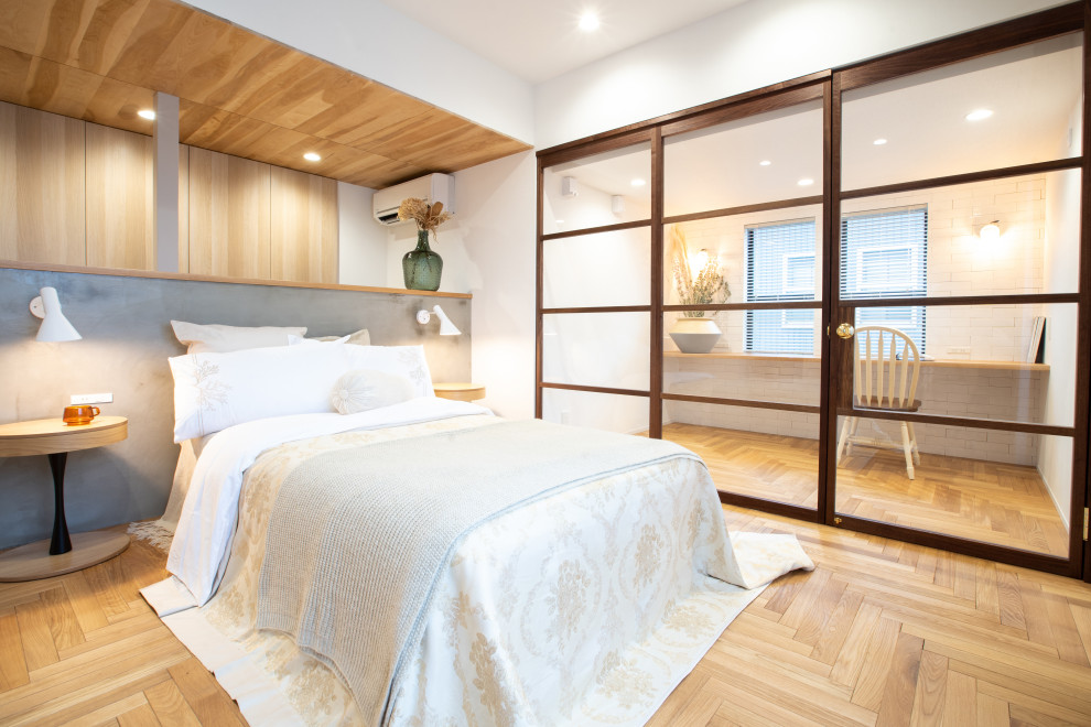 Modelo de dormitorio principal romántico sin chimenea con paredes blancas, suelo de madera en tonos medios, madera y papel pintado