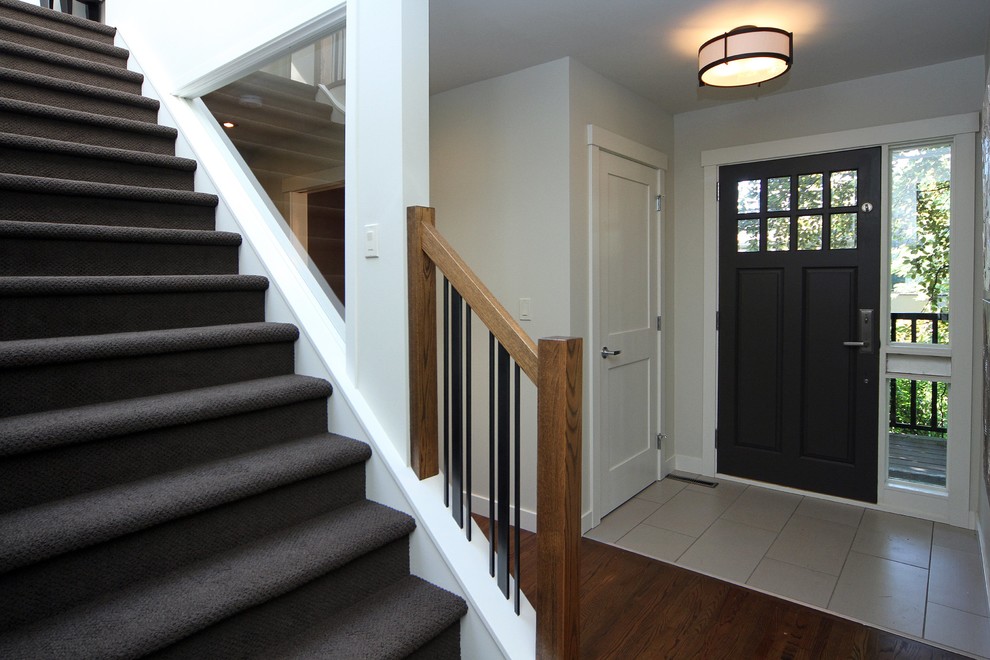 Small transitional entry hall photo in Calgary with white walls and a black front door