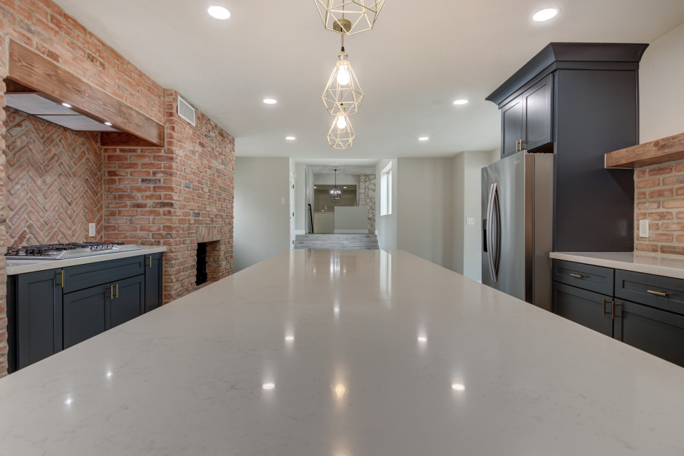 Mid-sized transitional u-shaped porcelain tile and gray floor eat-in kitchen photo in Phoenix with a farmhouse sink, shaker cabinets, blue cabinets, quartz countertops, red backsplash, brick backsplash, stainless steel appliances, an island and white countertops