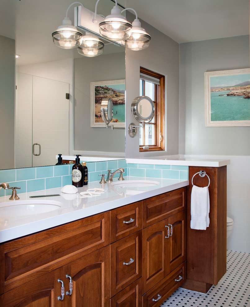 Photo of a large beach style master bathroom in San Francisco with an undermount sink, recessed-panel cabinets, medium wood cabinets, quartzite benchtops, an alcove shower, a one-piece toilet, blue tile, ceramic tile, grey walls and mosaic tile floors.