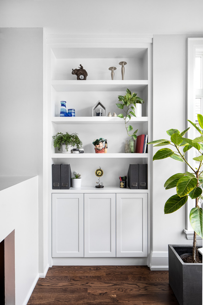 Design ideas for a mid-sized transitional home office in Toronto with a library, white walls, a two-sided fireplace, a plaster fireplace surround, a freestanding desk and panelled walls.