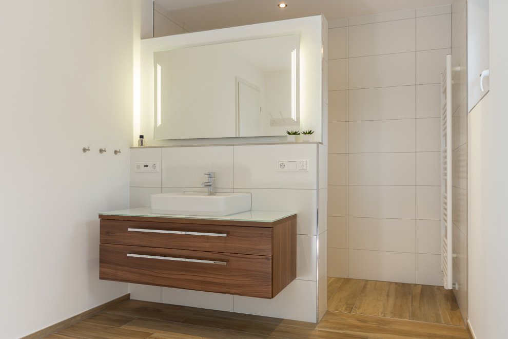 This is an example of a mid-sized midcentury bathroom in Other with an alcove shower, white tile, ceramic tile, white walls, light hardwood floors, a vessel sink, wood benchtops, an open shower and white benchtops.