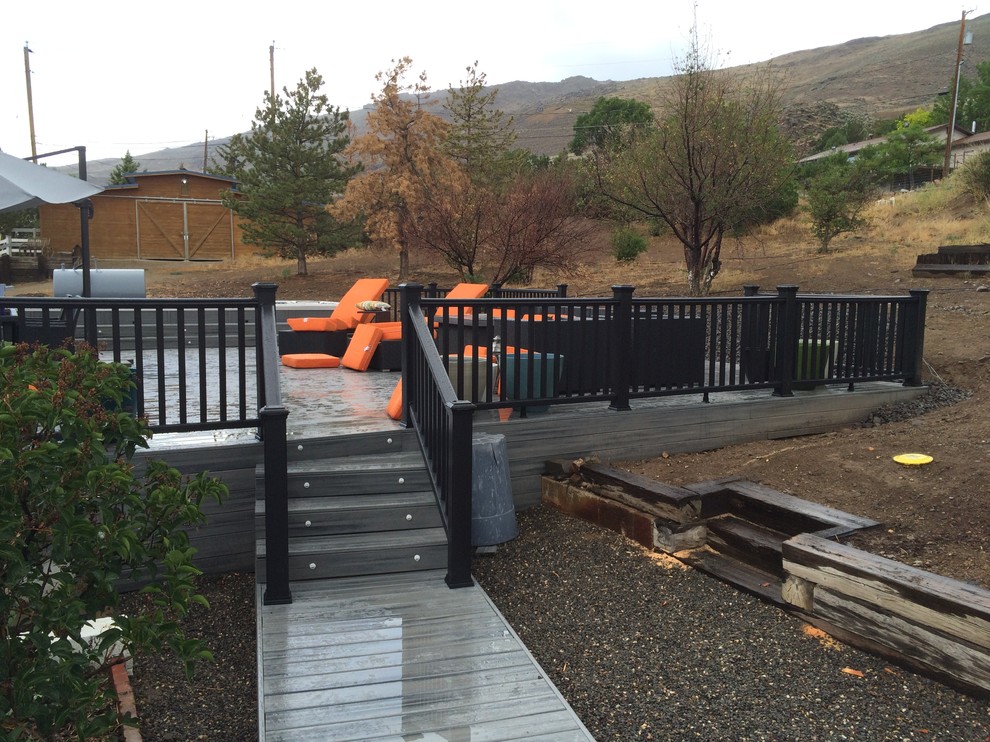 Example of a mid-sized mountain style backyard deck design with no cover