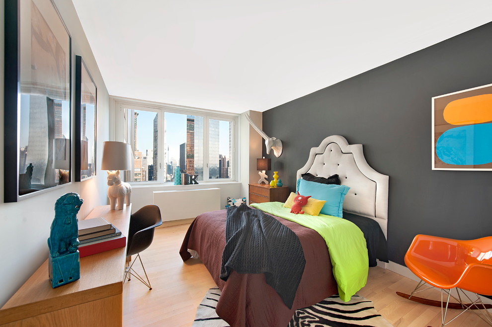 Photo of a contemporary kids' room for boys in New York with grey walls and light hardwood floors.