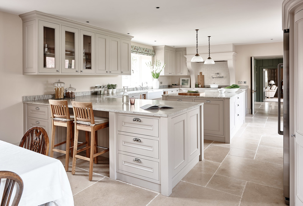 Country u-shaped eat-in kitchen in Gloucestershire with a farmhouse sink, beaded inset cabinets and beige cabinets.