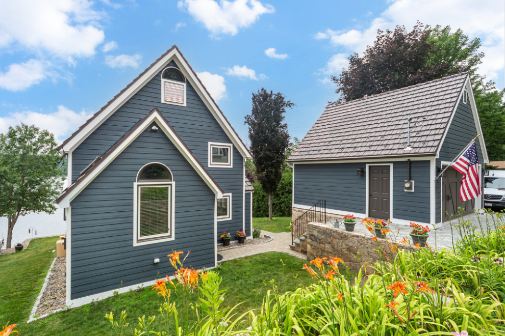 Diseño de fachada de casa azul y marrón tradicional de tamaño medio a niveles con revestimientos combinados, tejado a dos aguas, tejado de metal y tablilla