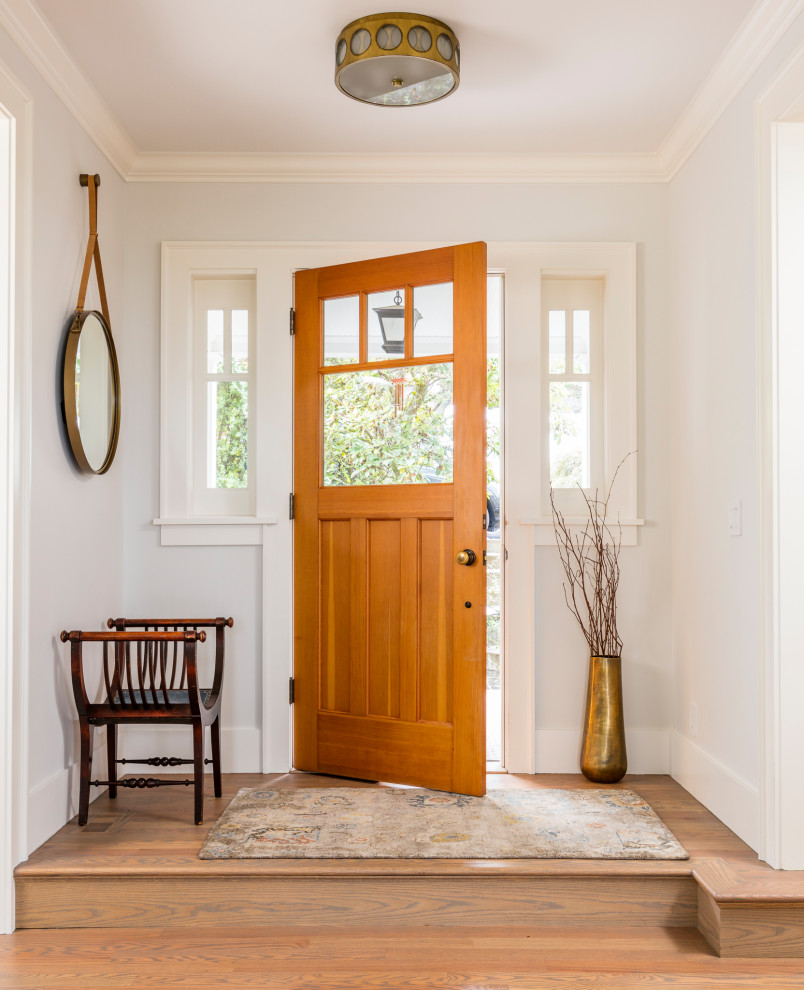 Transitional foyer in Seattle with white walls, light hardwood floors, a single front door, a light wood front door and grey floor.