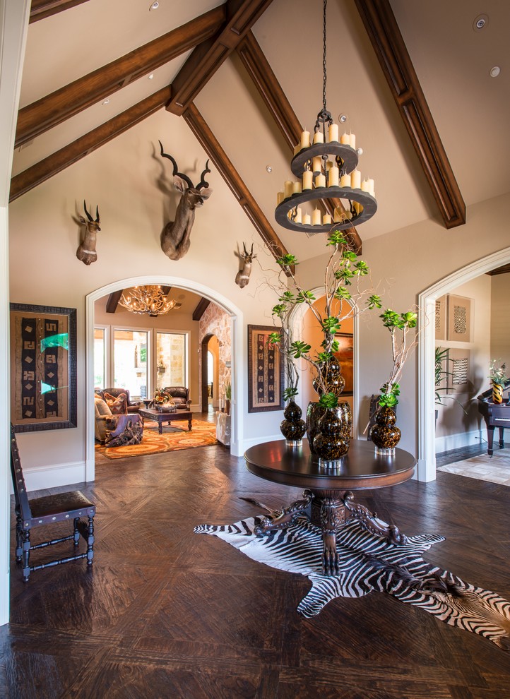 Large mountain style dark wood floor and brown floor foyer photo in Dallas with beige walls and a dark wood front door