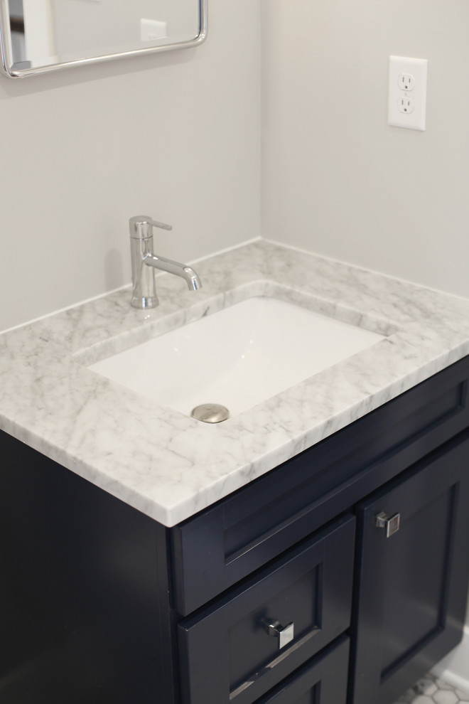 Inspiration for a mid-sized transitional master bathroom in Philadelphia with shaker cabinets, blue cabinets, a double shower, white tile, ceramic tile, grey walls, marble floors, an undermount sink, marble benchtops, a two-piece toilet, white floor and a hinged shower door.