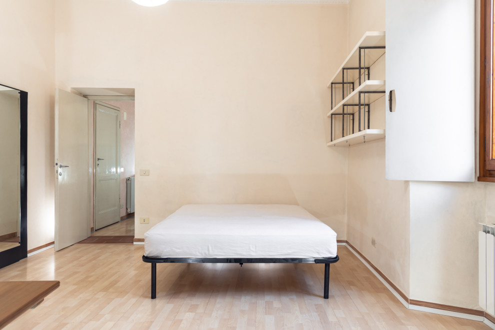 Esempio di una piccola camera matrimoniale design con pareti beige, pavimento in laminato e pavimento beige