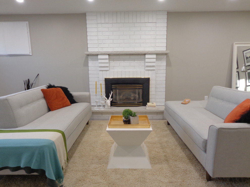 This is an example of a mid-sized transitional look-out basement in Toronto with beige walls, laminate floors, a standard fireplace, a brick fireplace surround and beige floor.