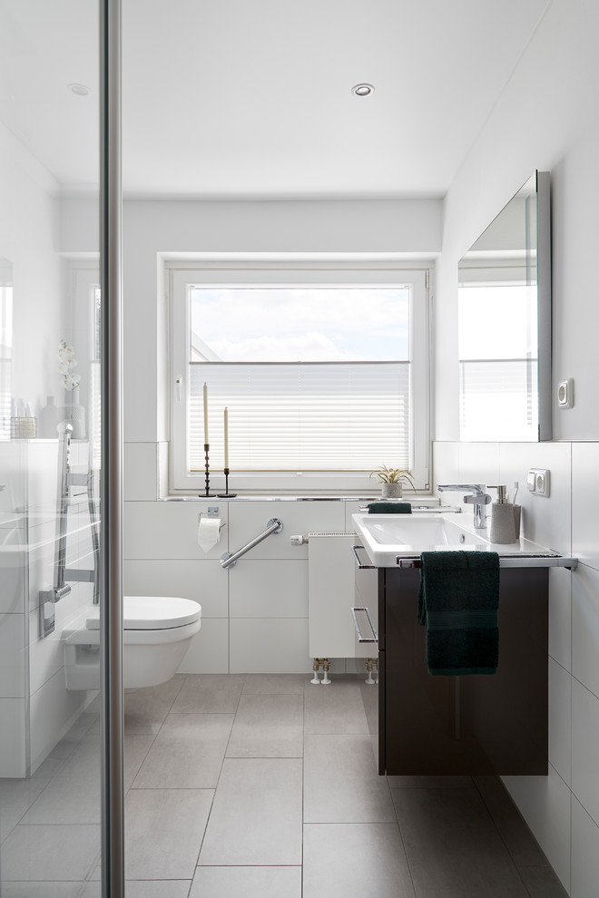 Photo of a large contemporary 3/4 bathroom in Other with flat-panel cabinets, brown cabinets, an open shower, white tile, ceramic tile, white walls, an integrated sink, brown floor, a wall-mount toilet, white benchtops, a single vanity, a floating vanity and ceramic floors.