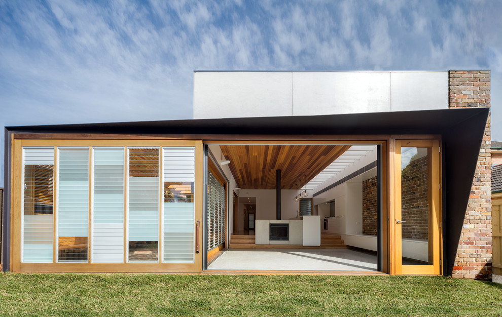 Contemporary one-storey exterior in Sydney with mixed siding and a flat roof.