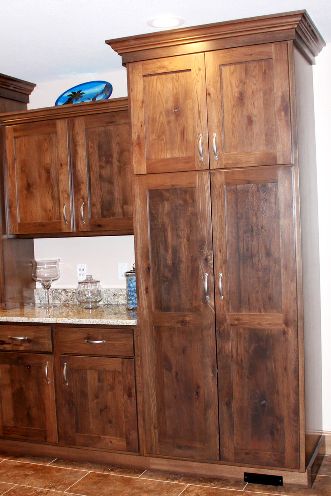 Example of a large mountain style l-shaped eat-in kitchen design in Chicago with a farmhouse sink, shaker cabinets, dark wood cabinets, granite countertops, stainless steel appliances and an island