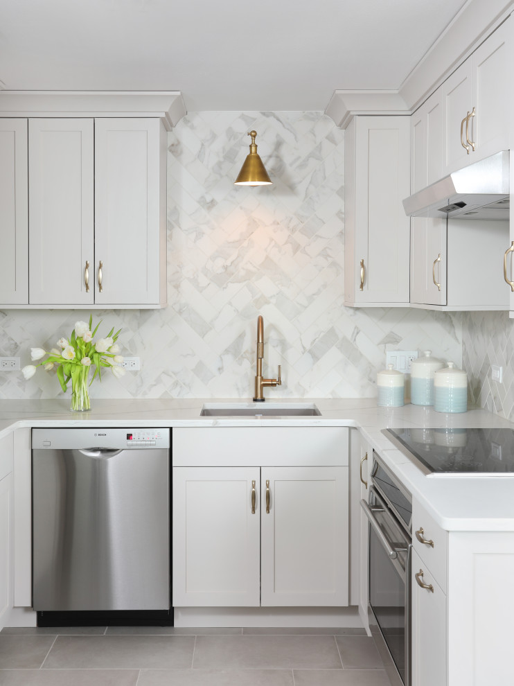 Inspiration for a mid-sized transitional u-shaped eat-in kitchen in Chicago with an undermount sink, grey cabinets, quartz benchtops, grey splashback, porcelain splashback, stainless steel appliances, porcelain floors, a peninsula, beige floor, white benchtop and flat-panel cabinets.