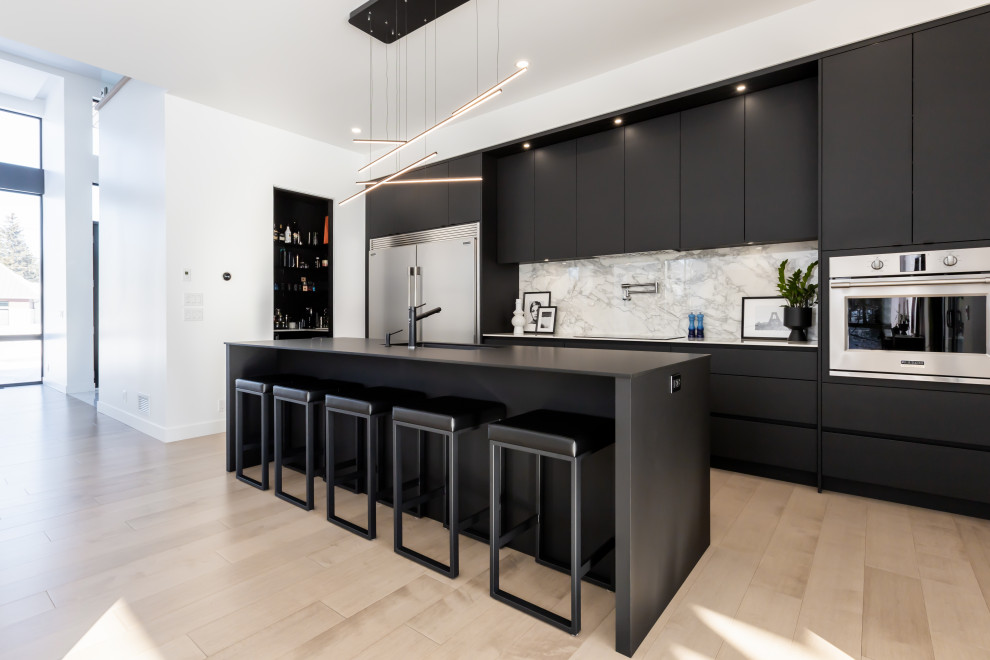Inspiration for a large contemporary galley light wood floor open concept kitchen remodel in New York with a double-bowl sink, flat-panel cabinets, black cabinets, quartzite countertops, multicolored backsplash, ceramic backsplash, stainless steel appliances, an island and black countertops
