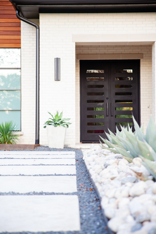 Inspiration for a mid-sized modern front yard full sun driveway in Dallas with with rock feature, gravel and a wood fence.