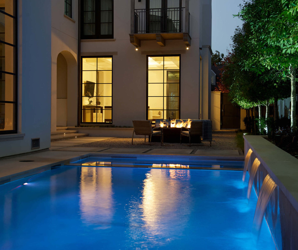 Design ideas for a mid-sized contemporary backyard rectangular pool in Dallas with a water feature and concrete pavers.