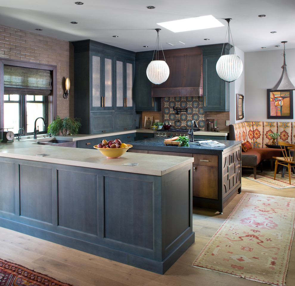 Design ideas for an eclectic u-shaped kitchen in Denver with a farmhouse sink, shaker cabinets, blue cabinets, concrete benchtops, light hardwood floors, with island and beige floor.