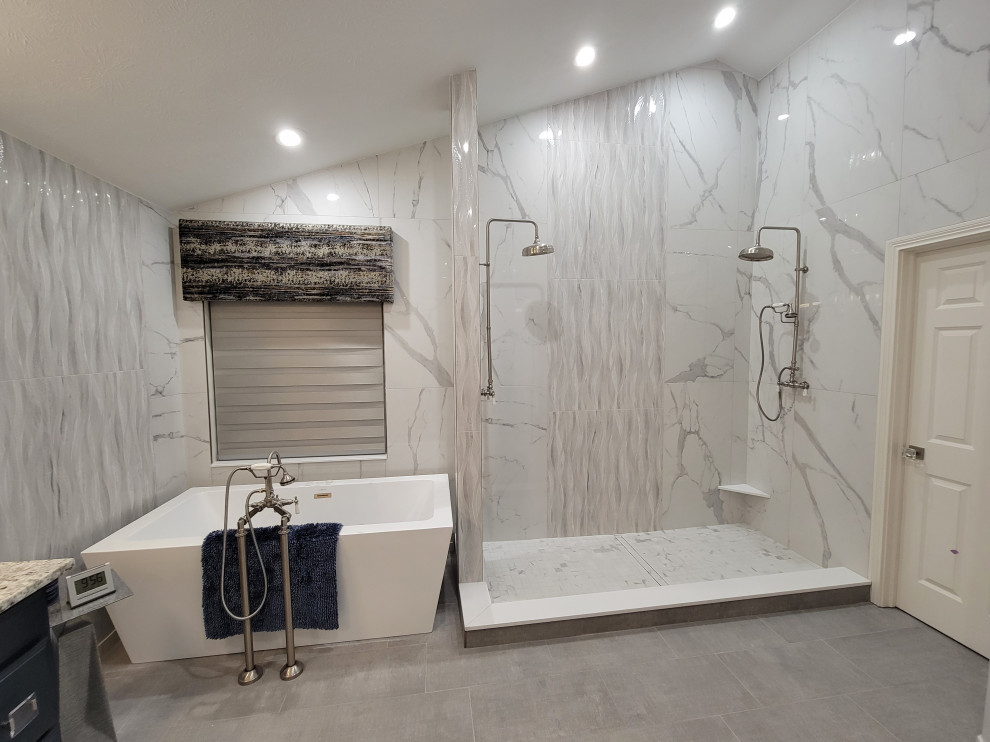 Inspiration för ett stort vintage flerfärgad flerfärgat en-suite badrum, med släta luckor, blå skåp, ett fristående badkar, en dubbeldusch, en bidé, vit kakel, marmorkakel, klinkergolv i porslin, ett integrerad handfat, granitbänkskiva, grått golv och med dusch som är öppen