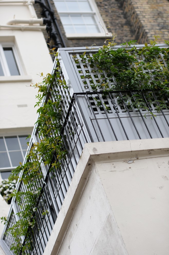 This is an example of a small traditional rooftop deck in London with a container garden and no cover.