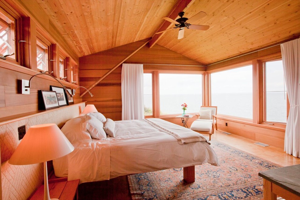 Foto de dormitorio principal costero de tamaño medio sin chimenea con paredes beige y suelo de madera clara