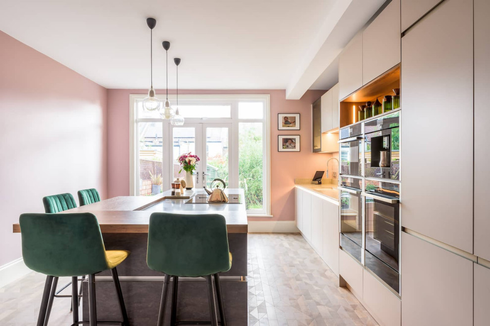 Inspiration for a large contemporary l-shaped open plan kitchen in Sussex with a single-bowl sink, flat-panel cabinets, pink cabinets, quartzite benchtops, black appliances, with island and white benchtop.