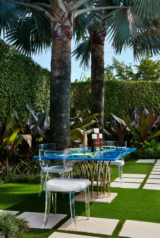 Tropical backyard patio in Miami with no cover.