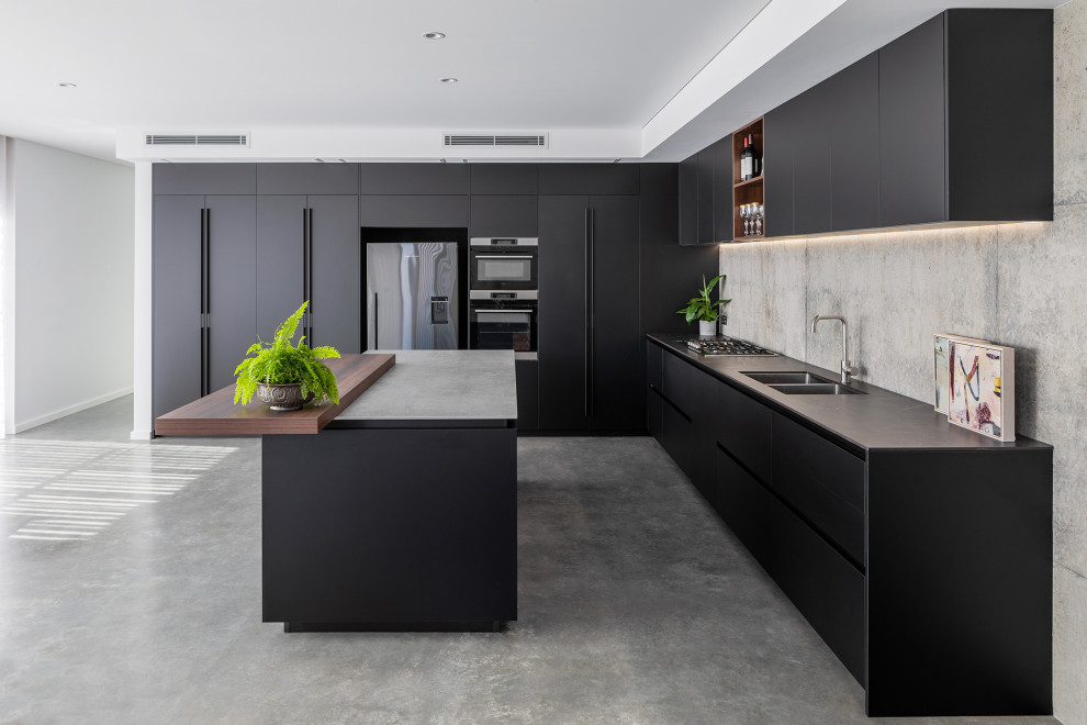 Inspiration for a large eclectic open plan kitchen in Perth with an undermount sink, green splashback, glass tile splashback, panelled appliances, concrete floors, with island and grey benchtop.