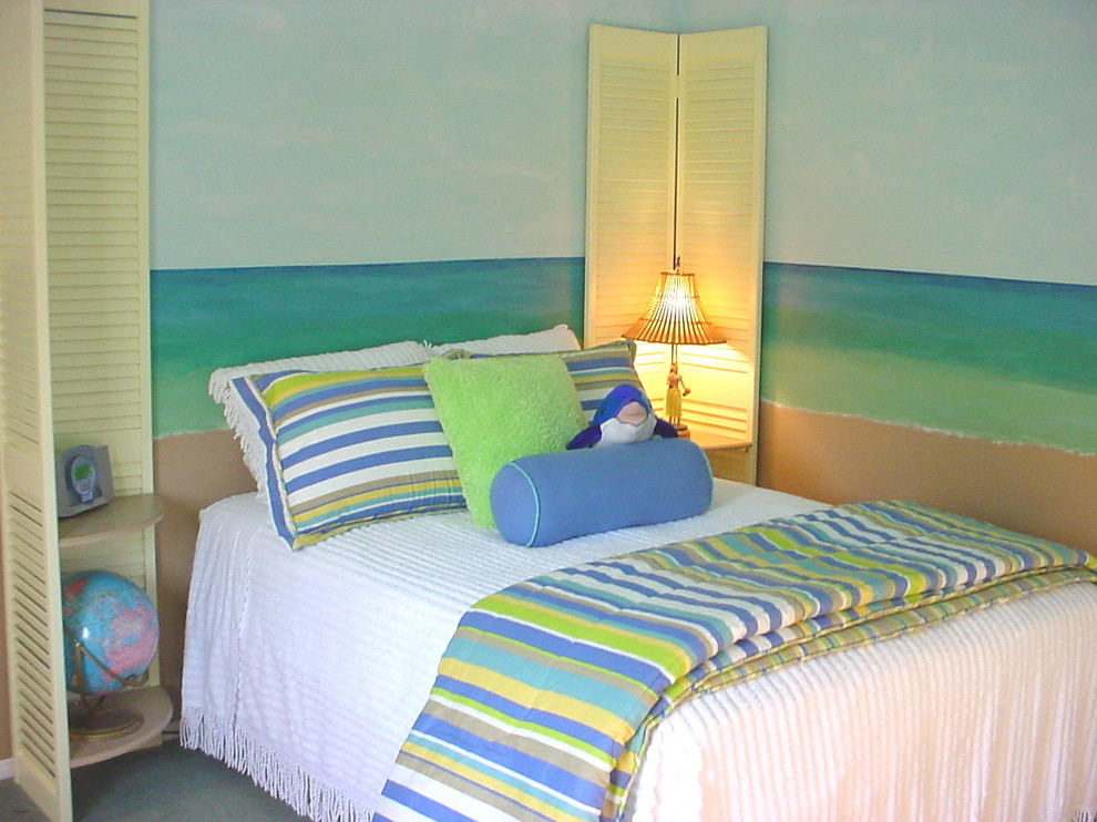 This is an example of a mid-sized beach style gender-neutral kids' bedroom for kids 4-10 years old in Los Angeles with carpet and multi-coloured walls.