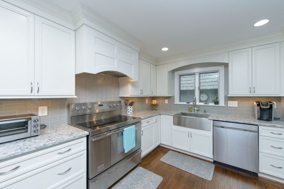 Transitional l-shaped medium tone wood floor eat-in kitchen photo in Baltimore with a farmhouse sink, beaded inset cabinets, white cabinets, granite countertops, gray backsplash, glass tile backsplash, stainless steel appliances and an island