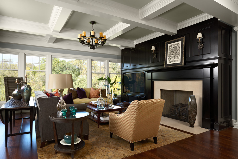 This is an example of a traditional living room in Minneapolis with black walls, dark hardwood floors, a standard fireplace and a built-in media wall.