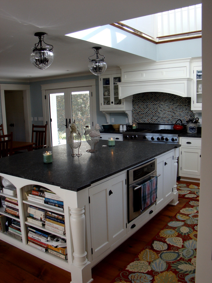 Design ideas for a mid-sized traditional l-shaped open plan kitchen in Portland Maine with a farmhouse sink, beaded inset cabinets, white cabinets, granite benchtops, multi-coloured splashback, glass tile splashback, stainless steel appliances, medium hardwood floors and with island.