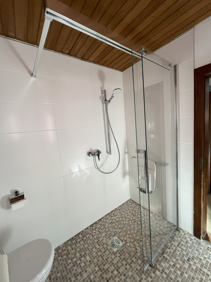 Exemple d'une petite salle de bain tendance avec une douche à l'italienne, WC suspendus, un carrelage blanc, des carreaux de céramique, un mur blanc, un sol en carrelage de terre cuite, un lavabo suspendu, un plan de toilette en surface solide, un sol beige, une cabine de douche à porte coulissante, un plan de toilette blanc, meuble simple vasque, meuble-lavabo suspendu, un plafond en lambris de bois et un mur en pierre.
