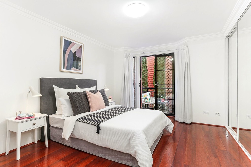 Inspiration for a transitional bedroom in Sydney with white walls, medium hardwood floors and red floor.