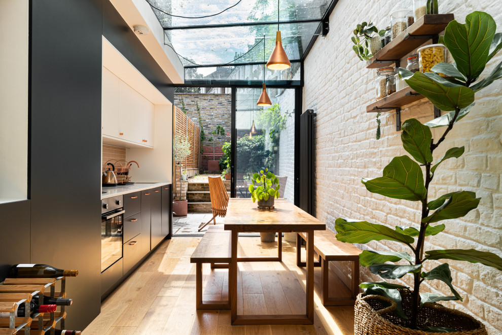 Idée de décoration pour une cuisine américaine design avec aucun îlot et un plan de travail blanc.