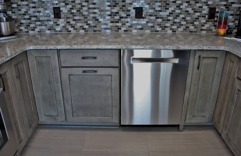 Inspiration for a small transitional u-shaped ceramic tile kitchen remodel in Charlotte with no island, flat-panel cabinets, distressed cabinets, granite countertops, gray backsplash, mosaic tile backsplash, stainless steel appliances and an undermount sink