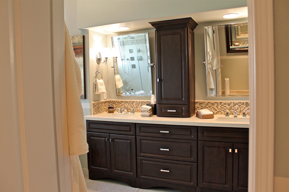 Large contemporary master bathroom in Orange County with raised-panel cabinets, dark wood cabinets, engineered quartz benchtops, a drop-in tub, a corner shower, a bidet, beige tile, porcelain tile, multi-coloured walls, porcelain floors and an undermount sink.