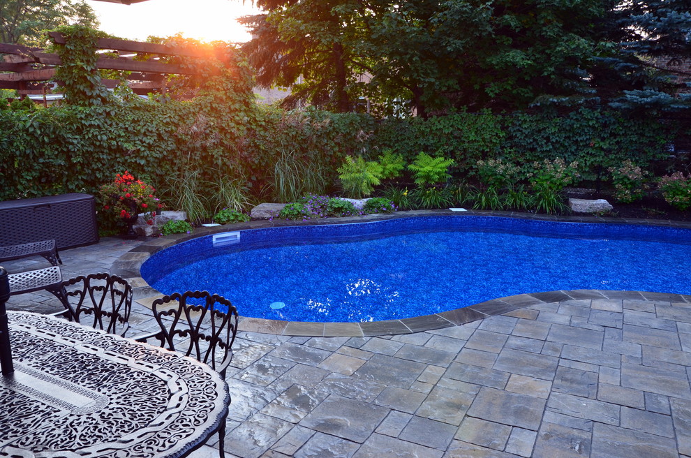 Pool fountain - mid-sized traditional backyard stone pool fountain idea in Toronto