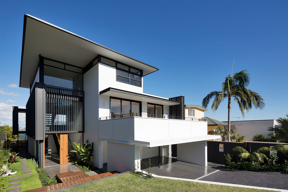Photo of a large contemporary three-storey white house exterior in Sydney with a flat roof, a metal roof and mixed siding.